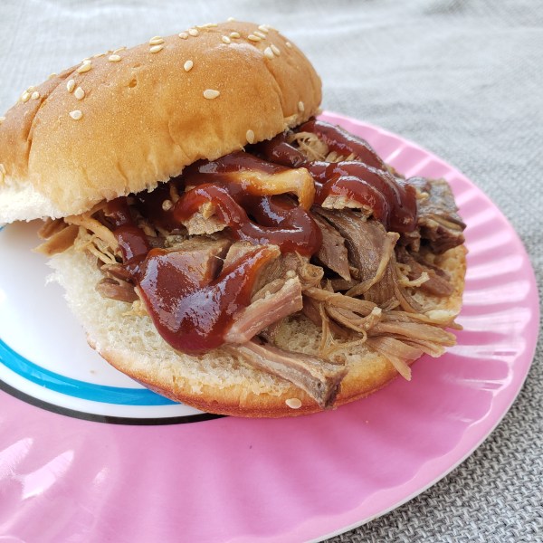 pulled pork sandwich on a seeded roll