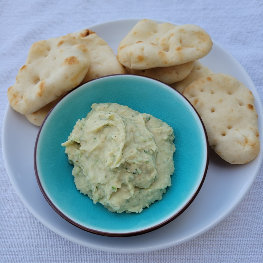 Bowl of garlic scrape white bean dip with mini pita 